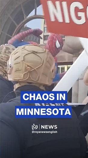 Person in Spider-Man costume jumps on Jake Lang during protest