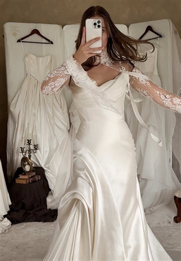 SCARLETTE | Step into timeless bridal allure with Scarlette’s fluid structure and sculptural silhouette. Sleek satin cascades into a beautifully contoured skirt, creating a shape that feels unmistakably unique. Transform this bridal look with the delicate lace of the IVY JACKET for a touch of gothic romance. Thinking Scarlette might be the ‘One’? Tap the link in our bio to book your Saint bridal appointment X #SaintBridal #WeddingDress #Bridetobe #Detailing #Bridal