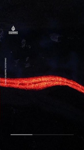Orange lava flows stream from Mount Etna
