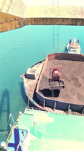 POV Supplaying coal to a Giant Cargo ship