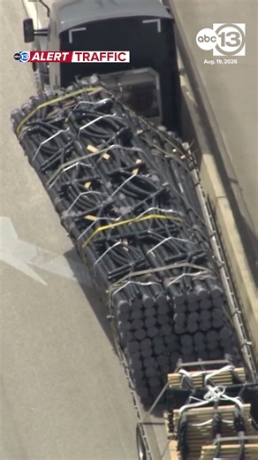 18-wheeler stalled on I-10 due to shifted load of pipes, stopping all westbound lanes.