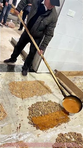 Traditional Handmade Sweet: Pouring Hot Brown Sugar Syrup over Roasted Nuts
