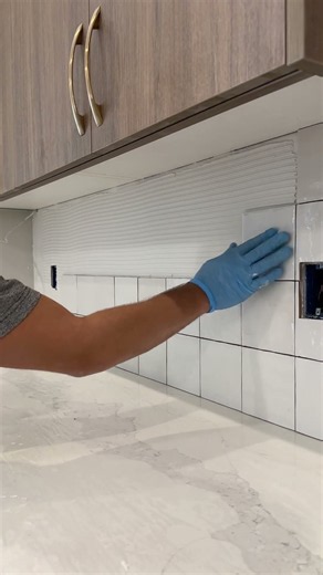 installing tiles on a kitchen backsplash