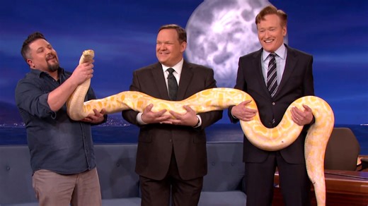 Conan gets cozy with a Burmese python. | Team Coco