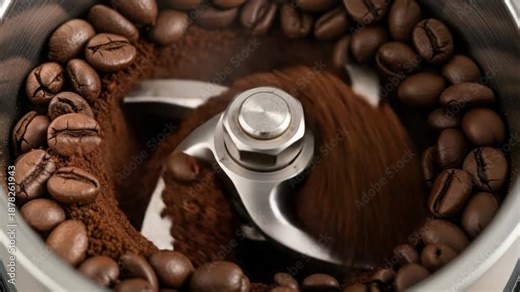 Close-up of coffee beans being ground in an electric grinder, creating fresh coffee powder.