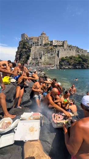 🇮🇹La dolce vita level: expert.Grilling in the shallow waters with a medieval castle backdrop during the heatwave.Ischia, Campania never change.Writer: Daniyal