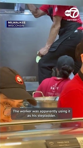 Panda Express employee stands on fryer while cleaning