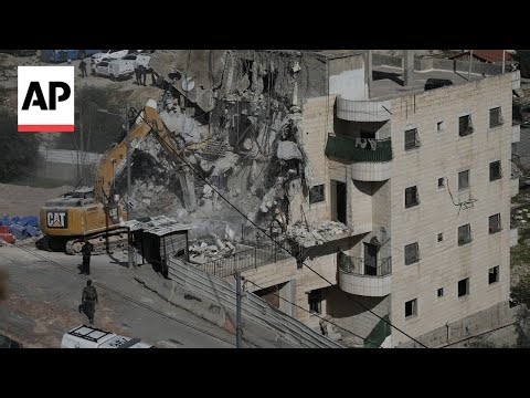 Palestinians watch in shock as Israel demolishes block of flats in Jerusalem
