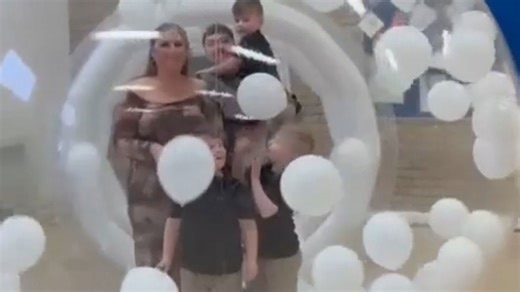 Pink confetti bursts inside balloon dome to reveal arrival of baby girl