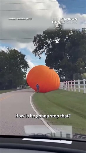 A massive inflatable pumpkin was spotted rolling away on a street😯