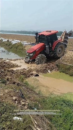 Tractor Stuck in Mud While Crossing Farm Ditch with Plow