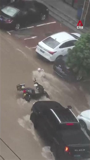 Drivers in China use vehicles to block delivery rider from being swept away by flood