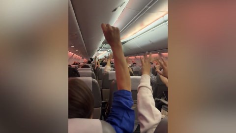 Cabin crew leads passengers in synchronised stretching exercises