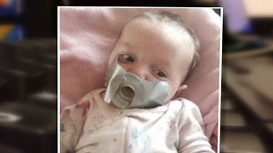 Grandma tapes pacifier to baby's mouth