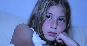 Child hypnotized by TV screen, little girl watching movie in the dark