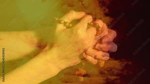 Animation of hands of person praying and holding a Christian rosary with cross over orange clouds mo