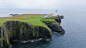 Aerial view of Lighthouse on a rocky cliff-top overlooking a causeway and the coastline in Scotland. Travel destination, tourist attraction landmark of Scottish Neist Point Lighthouse on Isle of Skye.