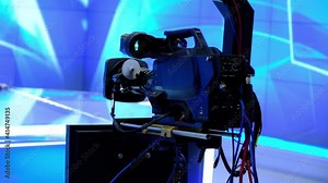 A camera with a prompter on it is moving over the crane arm. (Camera jib)