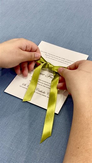 Never tie a bad bow again 🎀✨ Follow along as we show you how to tie a polished, pretty ribbon bow for your wedding invitations—the kind that looks effortless (but perfect) 💌 How to tie the bow: 1️⃣ For a 5×7 invitation, start with at least 25 inches of ribbon. 2️⃣ Cross the ends once and gently pull snug, leaving one tail above and one below the center. 3️⃣ Hold the center tight with one finger. Loop the top ribbon toward you, then wrap the bottom ribbon around and through the opening, folding