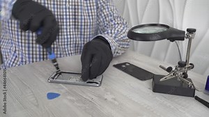 Close-up of a cell phone repair. The internal components of a smartphone. Disassembled cell phone. Cell Phone Battery. Master disassembled mobile device for detail. Chips and details of the smartphone