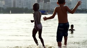 Kids playing in water on a beach in Brazil