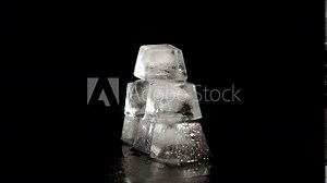 Some ice cube in black background. Some transparent ice cubes lay on the table on the black background.