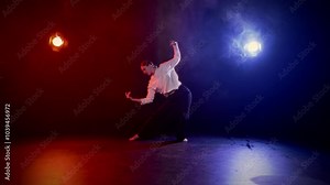 Young woman dancing contemporary choreography in studio, slow motion shot. Beautiful teen girl performing modern dance, training alone in rehearsal room in school of arts, hobby, red and blue soffits