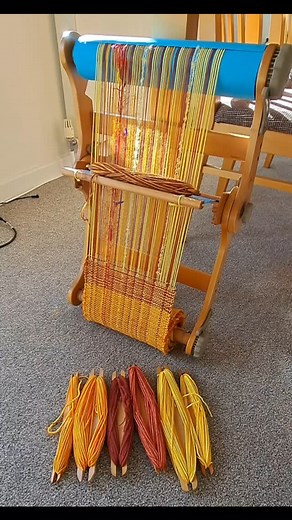 Wear Your Weaving! 260in warp, 7.5dpi, on my 12in Ashford Knitters loom. I'm weaving narrow panels which I'll stitch together then cut out a coat. I've wound the shuttles so I don't have to pause. Numbered sheets on the back roller help me to keep track of how much I have left to weave. #weaversofinstagram #sewersofinstagram #ashfordknittersloom | Sarah Howard