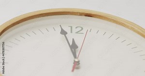 White wall clock tells the time 12 o'clock. It's time to take a break and eat.