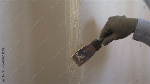 drywall construction repair concept. Worker install plasterboard walls putting stucco on mesh tape. plaster