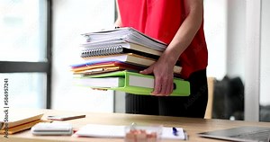 Female hands of trainee secretary hold stack of folders and documents. Overtime work time management and internship in company