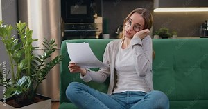 Good looking caucasian girl working with smartphone and documents collating data and checking reports of employees. Business woman makes call phone, works remotely with papers works at home