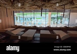 A relaxation room in a spa center with soft hay and comfortable lounge chairs creates a warm, calming atmosphere for rest.