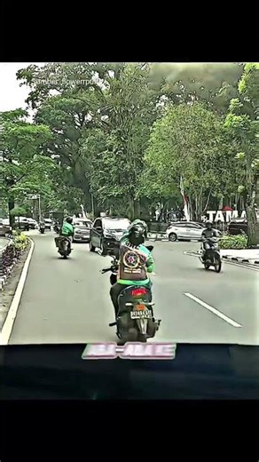 Two motorcycle taxi drivers help clear a narrow road for an ambulance.