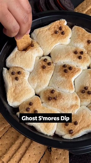 Snack time just got 👻 SPOOKY 👻 Secure that Halloween party invite by making this Ghost S’mores Dip! 🍫 It’s ooey, gooey, and perfect for all your boos. Get the recipe down below or at the link in the @allrecipes bio! 👇 Ingredients: 1 (12 ounce) bag chocolate chips 1 (10 ounce) package large marshmallows 1 (14.4 ounce) package graham crackers (such as Honey Maid) Directions: Gather all ingredients. Preheat the oven to 350 degrees F (175 degrees C). Spread chocolate chips in the bottom of a gla