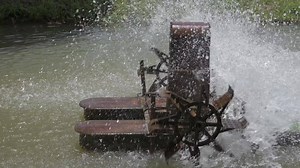 Download Old rusty floating water turbine rotating wheel paddles for increasing oxygen quality in water source. Splashing water. Slow motion. for free