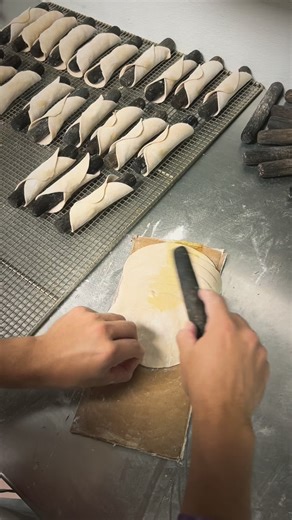 Step Three of our Cannoli Making Process: Each shell gets wrapped around a wood stick ➡️ placed on the screen to go in the fryer Make sure to follow along for Step Four, coming tomorrow!! #varallobrothersbakery #cannoli #growingupitalian #bakery | Varallo Brothers Bakery