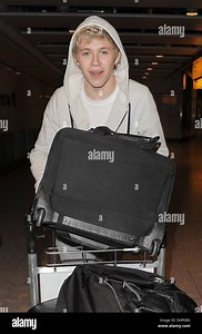Niall Horan One Direction arrive at Heathrow Airport on alate night flight from Sweden. Despite it being almost midnight, they were swamped by around 70 female fans as they made their way to their car. London, England - 15.05.12 Stock Photo - Alamy
