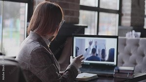 distance learning, a successful young woman actively leads a diologist with a video communication teacher, passing a business training online raises her hand and takes notes in a notebook while a