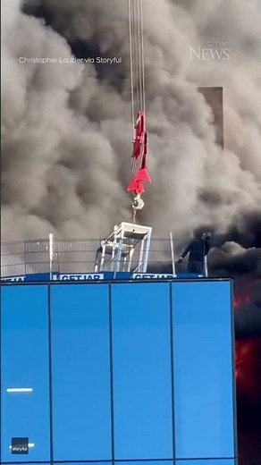 Dramatic video shows worker's rescue from roof of burning building