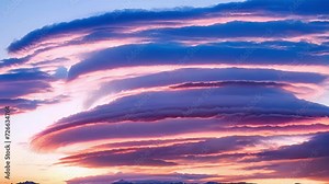 A spectacular sunset sky filled with lenticular clouds that seem to hang weightlessly in the air.