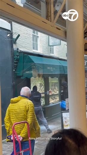 Two masked men armed with a sledgehammer smashed through the window of a west London jewelry store in broad daylight on Saturday morning, January 31, and grabbed multiple items from a display window before fleeing on foot. Dramatic footage captured by Amy Hilton opposite the Gregory & Co jewelry shop in Richmond shows one of the two suspects repeatedly hitting one of the shop’s windows with a sledgehammer, while the other suspect waits by his side holding an empty Ikea bag. | ABC 7 Chicago