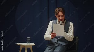 StandUp cafe, comedy concert. Man telling jokes on stage. Male comedian speaks with audience using microphone, humorous monologue. Mentor coach training. Public speaking masterclass.