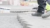 laying interlocking pavers during the construction of sidewalks and...