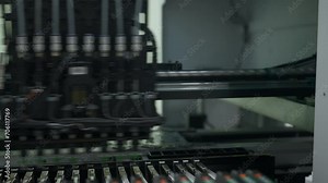 Factory machine at work: printed circuit board being assembled with automated mechanism. Creative. Technological background with modern equipment.