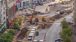 Excavator working on earthmoving at open pit mining in the city street timelapse.