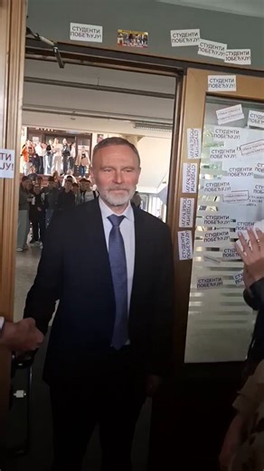 Direktor Jovine gimnazije Radivoje Stojkovic stoji na ulazu u školu dok mu vicu "Ostavka".