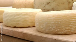 Cheese from whey and milk at home. Hard homemade cheese. Hard cow cheese on a wooden board. Craft cheese on a wooden board.