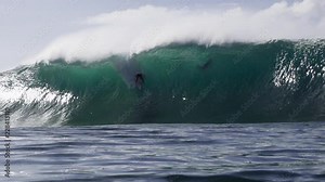 Surfer wiping out and perfect empty wave spitting at Banzai Pipeline, North Shore of Oahu, Hawaii.