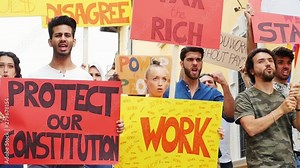 Public demonstration on the street against social problems and human rights. Group of multiethnic people making public protest